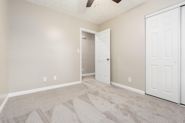 unfurnished bedroom featuring light carpet, ceiling fan, and a closet