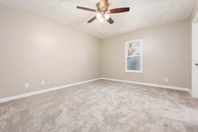 carpeted empty room featuring ceiling fan and a textured ceiling