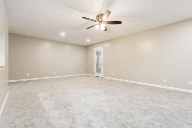 carpeted spare room with ceiling fan and a textured ceiling