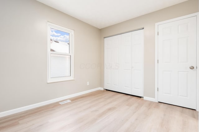 unfurnished bedroom featuring a closet and light hardwood / wood-style floors