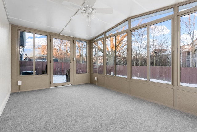 unfurnished sunroom featuring ceiling fan, lofted ceiling, and a healthy amount of sunlight