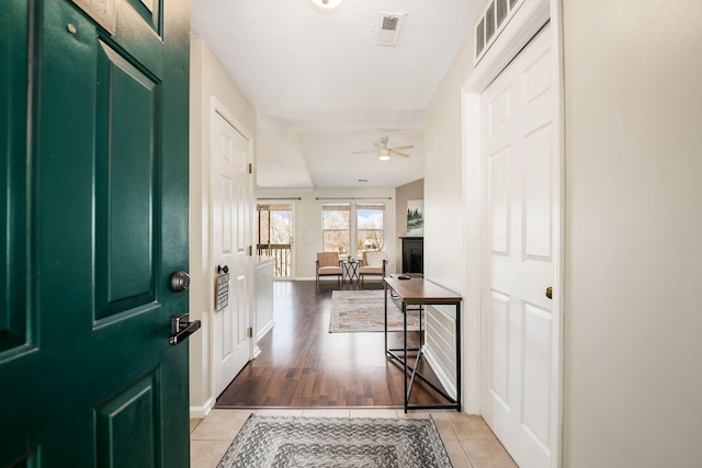 entryway featuring ceiling fan, a textured ceiling, and light tile patterned floors