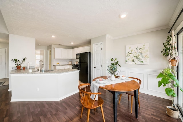 dining room with crown molding, sink, a textured ceiling, and dark hardwood / wood-style floors