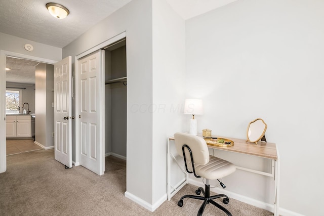 carpeted office space featuring a textured ceiling