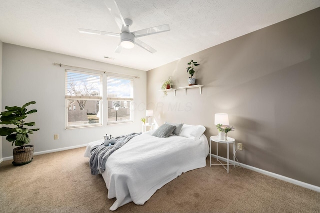 carpeted bedroom with ceiling fan and a textured ceiling