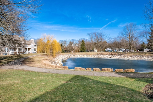 view of swimming pool featuring a water view and a yard