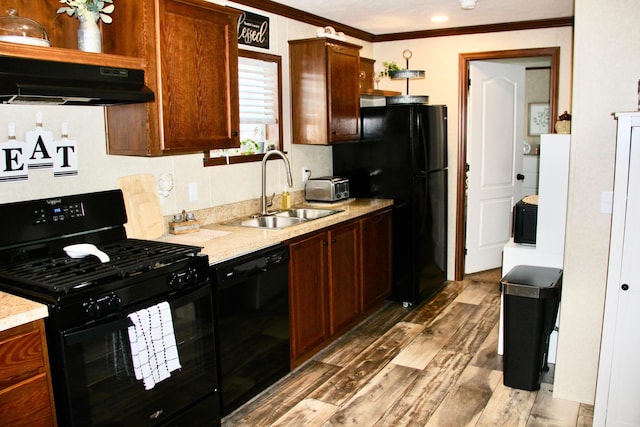 kitchen with black appliances, extractor fan, light hardwood / wood-style floors, sink, and crown molding