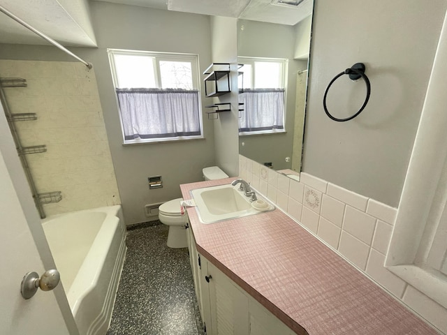 full bathroom featuring toilet, vanity, decorative backsplash, and shower / bathing tub combination