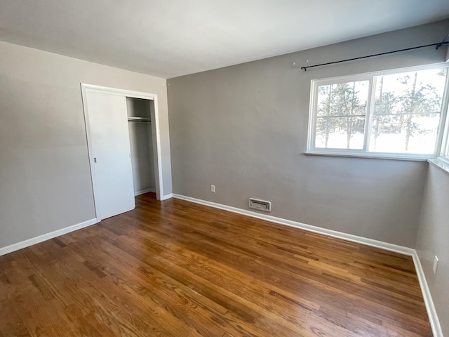 unfurnished bedroom with a closet and wood-type flooring