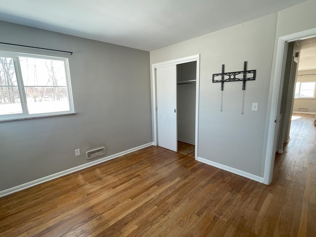 unfurnished bedroom featuring a closet and wood-type flooring