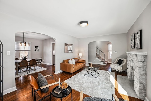 living room featuring dark hardwood / wood-style floors and a stone fireplace