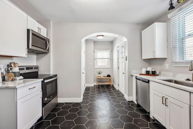 kitchen with sink, white cabinets, and stainless steel appliances