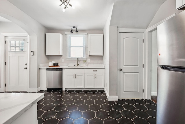 kitchen featuring white cabinets, stainless steel appliances, light stone counters, and sink