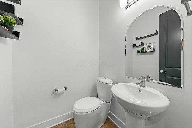 bathroom with sink, toilet, and hardwood / wood-style floors