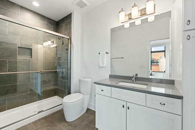 bathroom with vanity, tile patterned floors, a shower with door, and toilet