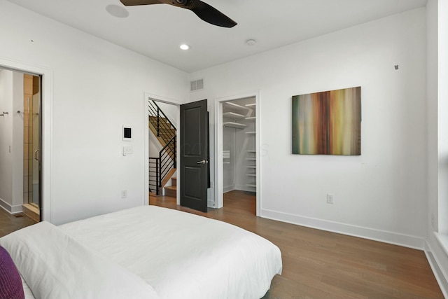 bedroom featuring dark hardwood / wood-style floors, ceiling fan, a spacious closet, and a closet