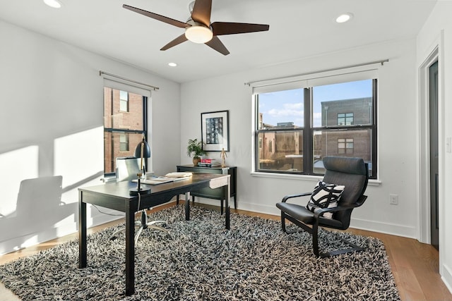 home office featuring wood-type flooring, a wealth of natural light, and ceiling fan