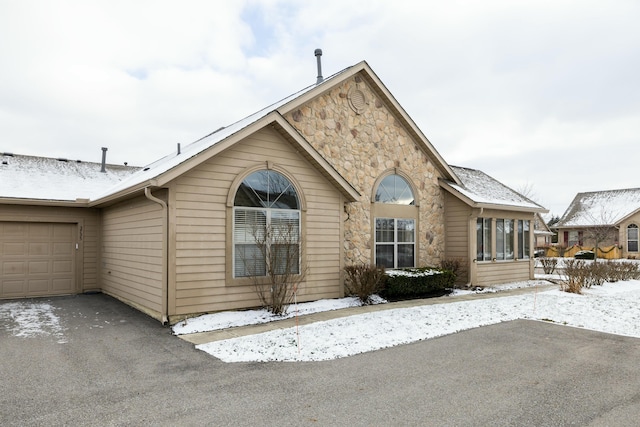 view of snow covered exterior featuring a garage