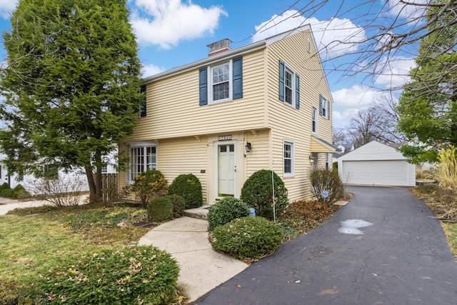 colonial home with a garage and an outbuilding