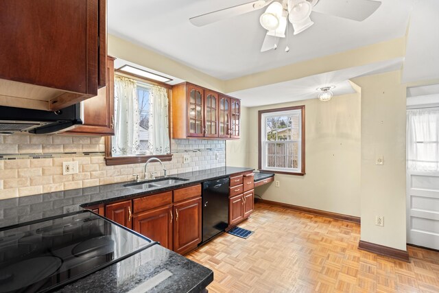 kitchen featuring dishwasher, tasteful backsplash, a sink, and a healthy amount of sunlight