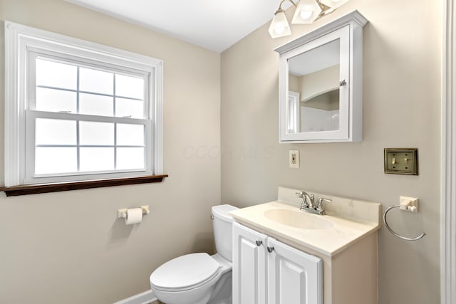 bathroom featuring baseboards, vanity, and toilet