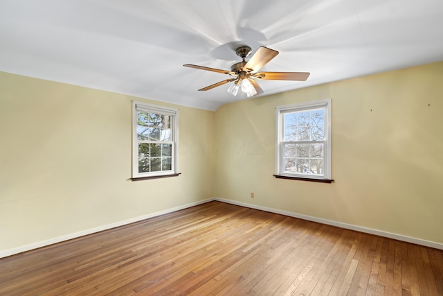 unfurnished room with wood-type flooring, vaulted ceiling, baseboards, and ceiling fan