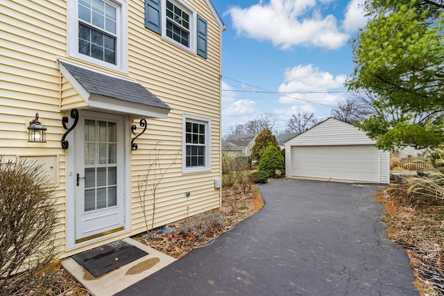 entrance to property with a garage and a shingled roof