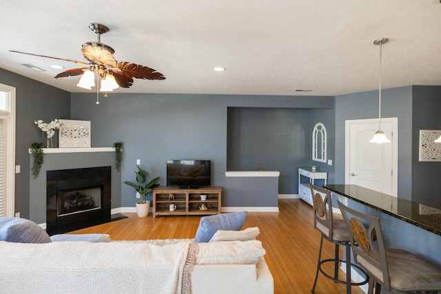 living room with hardwood / wood-style flooring and ceiling fan