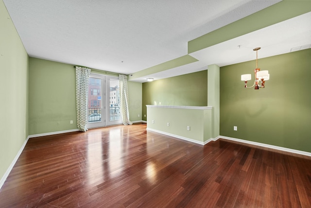 empty room with a chandelier and hardwood / wood-style floors