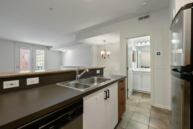 kitchen featuring appliances with stainless steel finishes, decorative light fixtures, light tile patterned floors, sink, and white cabinetry