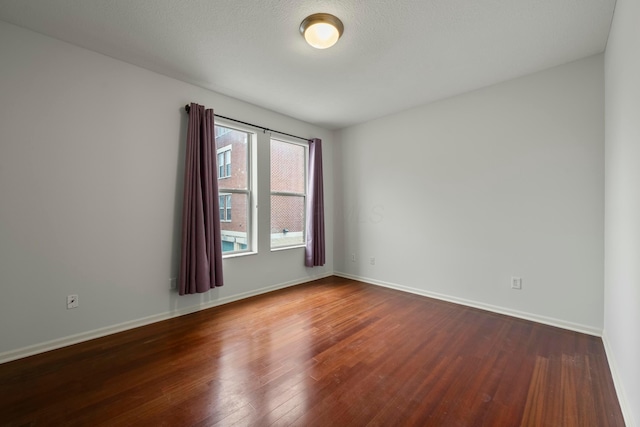 spare room featuring dark wood-type flooring