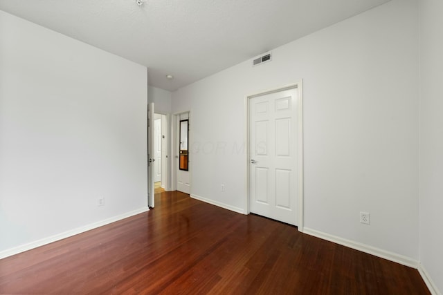 unfurnished bedroom with dark hardwood / wood-style flooring