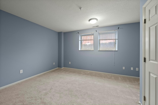 unfurnished room with light carpet and a textured ceiling