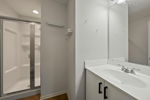 bathroom featuring vanity and a shower with door