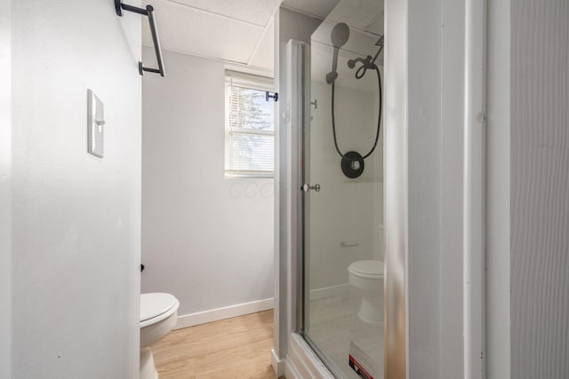 bathroom featuring wood-type flooring, toilet, and walk in shower