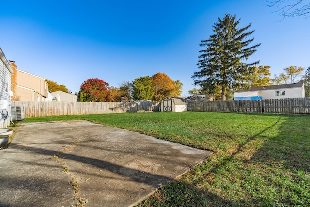 view of yard featuring cooling unit, a storage shed, and a patio area