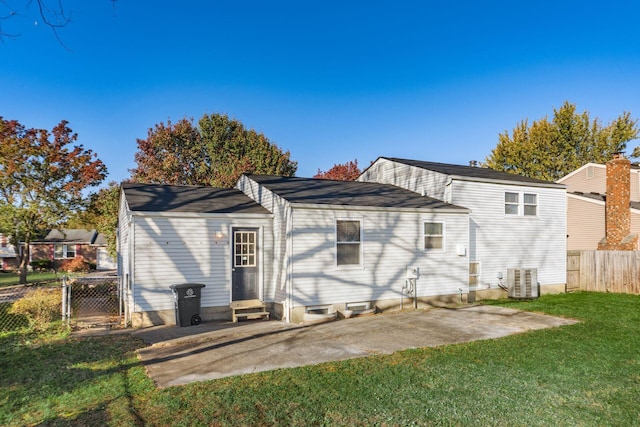 rear view of house featuring a patio, cooling unit, and a lawn