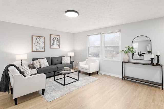 living room with light hardwood / wood-style floors and a textured ceiling