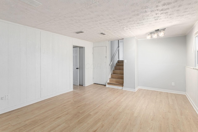 basement with a textured ceiling and light wood-type flooring