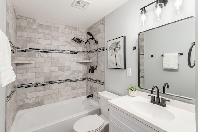 full bathroom featuring vanity, tiled shower / bath, and toilet