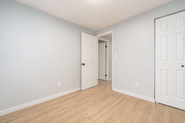 unfurnished bedroom featuring a closet and light hardwood / wood-style flooring