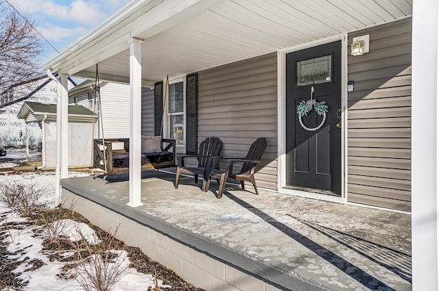 snow covered patio featuring a porch