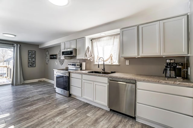 kitchen featuring appliances with stainless steel finishes, light hardwood / wood-style floors, and sink