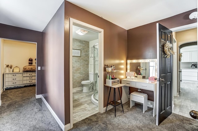 bathroom with toilet, a shower, and hardwood / wood-style flooring