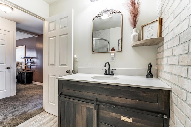 bathroom featuring hardwood / wood-style flooring, vanity, and an enclosed shower