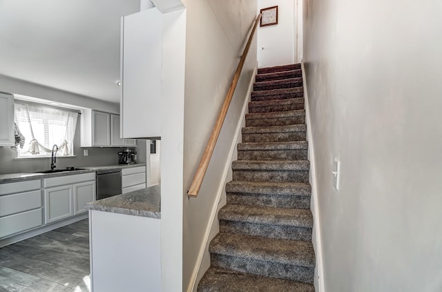 stairway featuring wood-type flooring and sink