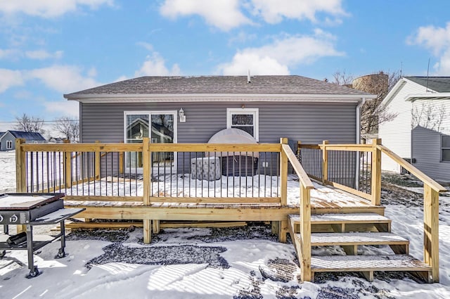 snow covered rear of property featuring a deck