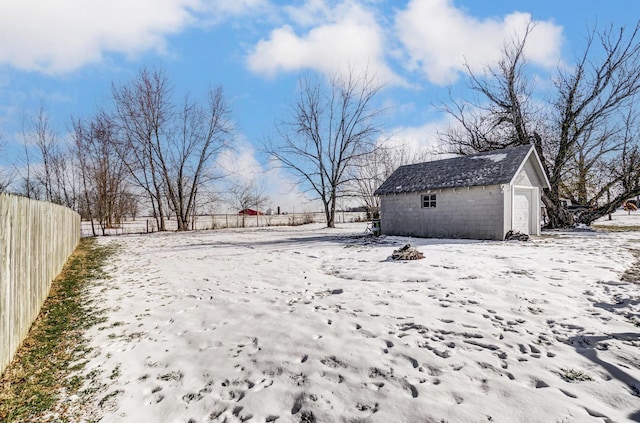 snowy yard with an outdoor structure and a garage