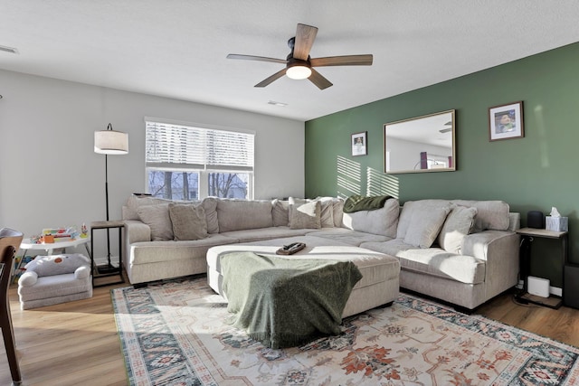 living room featuring ceiling fan and light hardwood / wood-style flooring