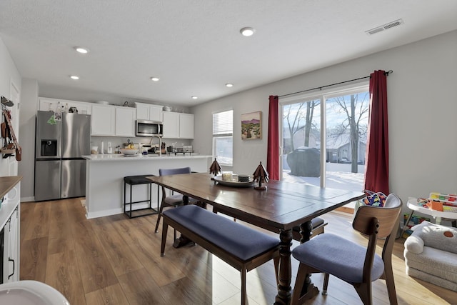 dining area with hardwood / wood-style floors and a textured ceiling